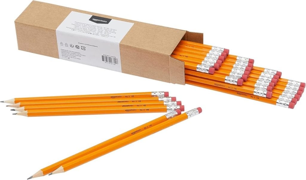 A cardboard box with several yellow pencils inside, and eleven yellow pencils with erasers laid out in front on a white background.