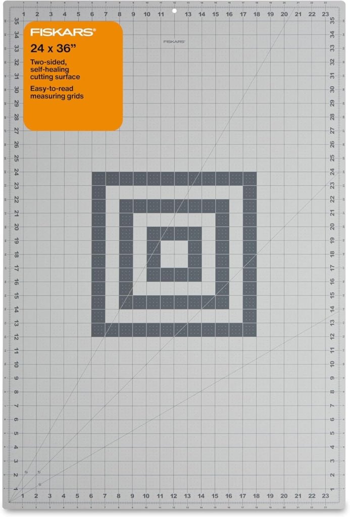 Fiskars 24 x 36-inch self-healing cutting mat with gridlines and a concentric square pattern in the center for precise measuring and cutting.