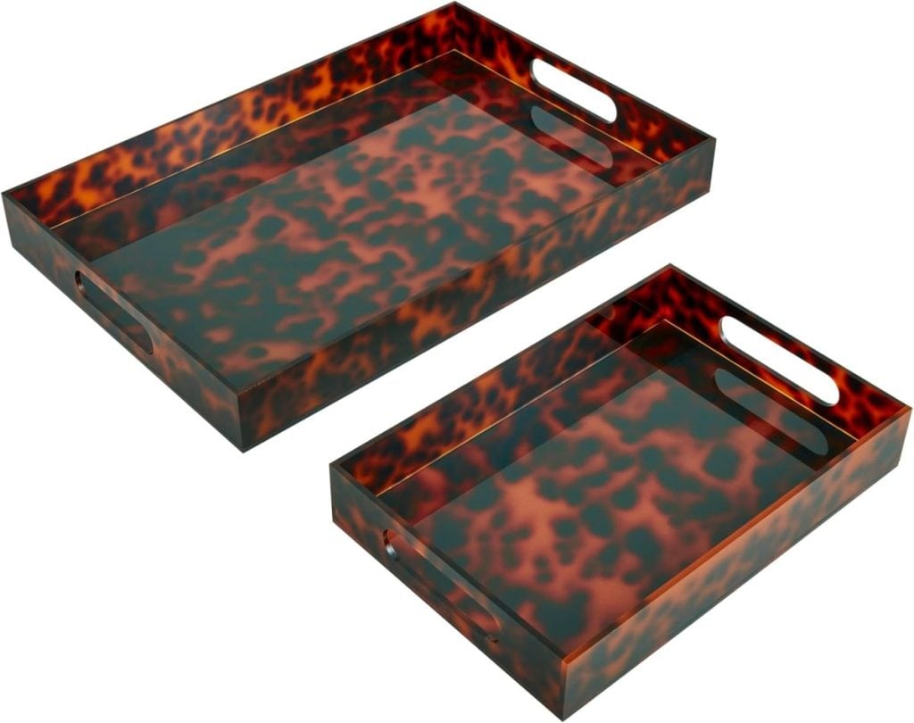 Two rectangular serving trays with tortoiseshell patterns and cutout handles, one larger and one smaller, placed side by side.