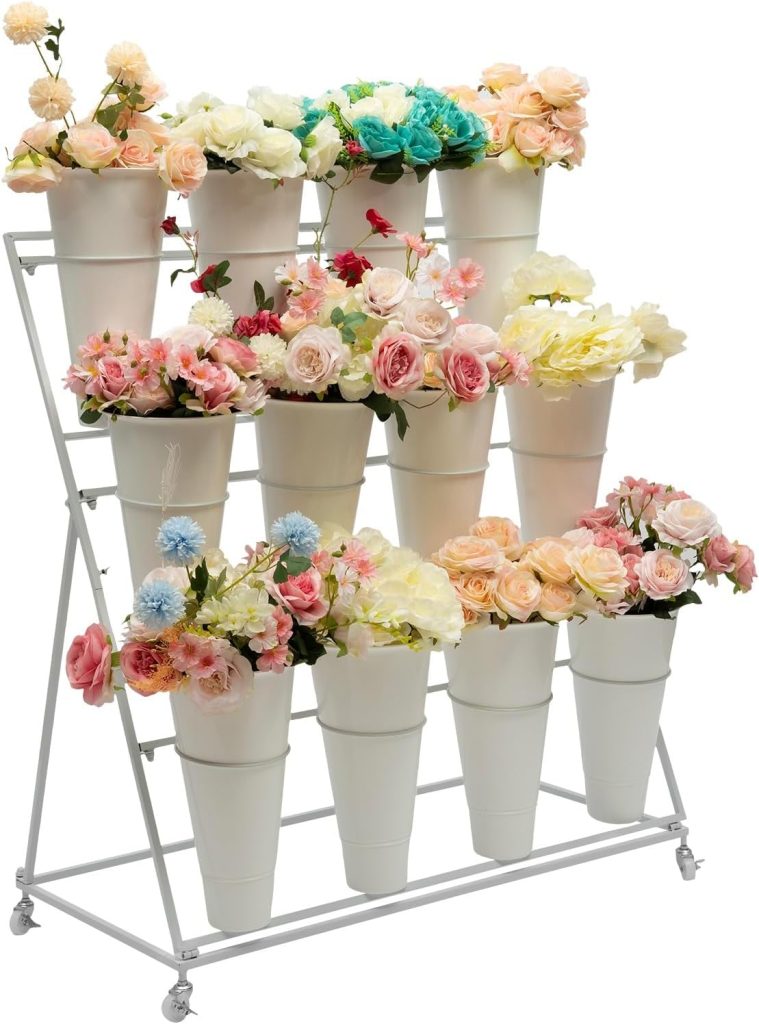 A metal rack holds three rows of white flowerpots, each containing assorted artificial flowers in various colors including pink, white, yellow, and blue.