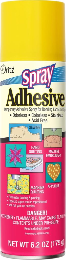 A can of Dritz Spray Adhesive, 6.2 oz, for fabric or paper, odorless, colorless, acid-free, with warnings about flammability and instructions for sewing uses.