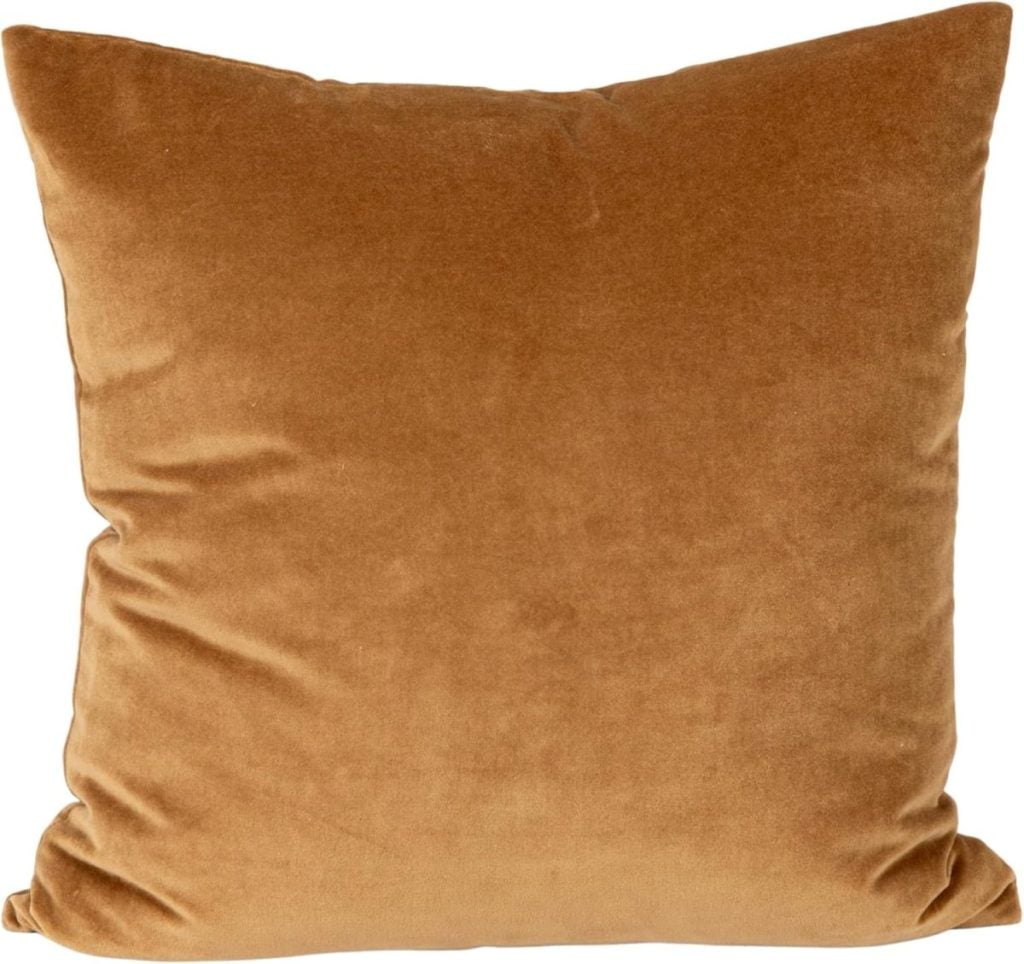 Square, light brown velvet pillow with a soft texture and slightly indented corners, shown against a white background.