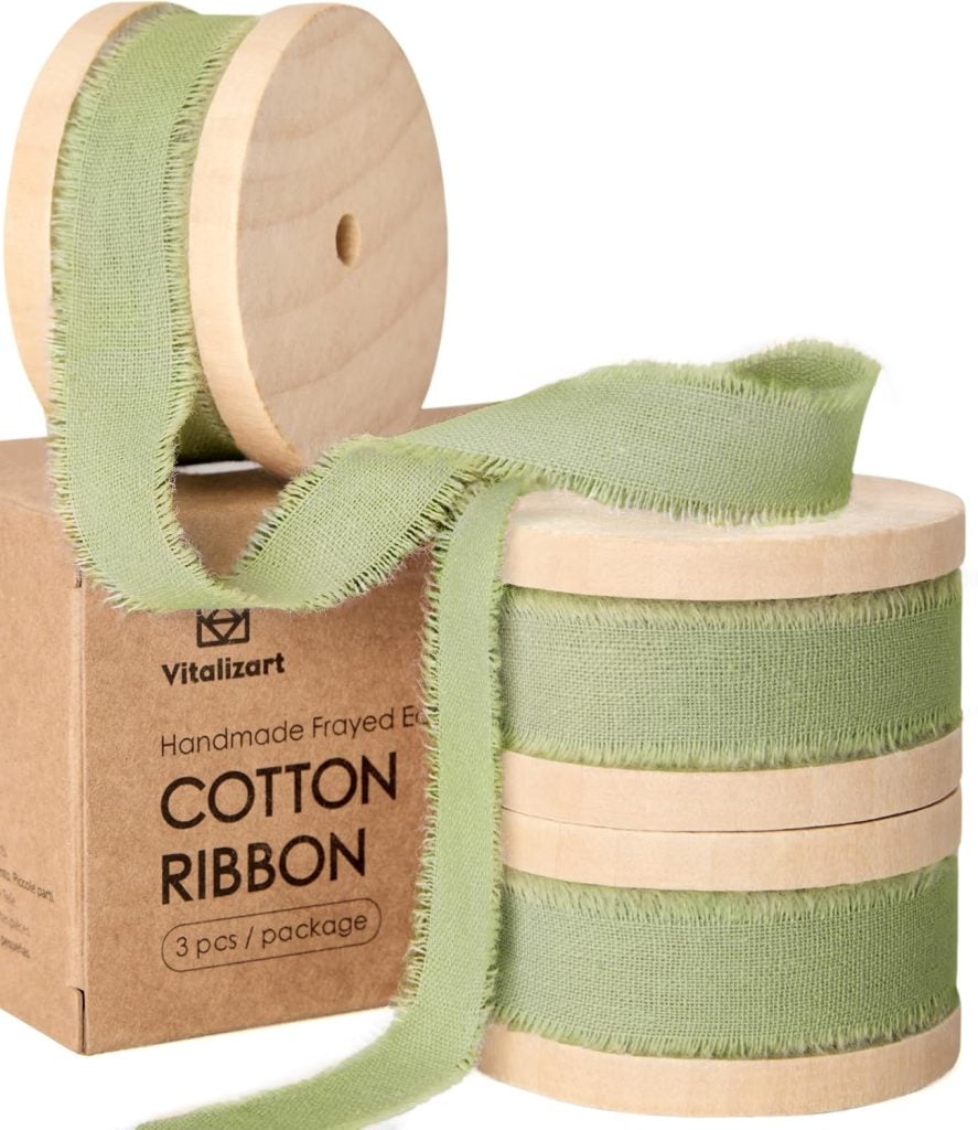 Three spools of light green frayed edge cotton ribbon are stacked on a brown box labeled "Handmade Frayed Edge Cotton Ribbon, 3 pcs/package.