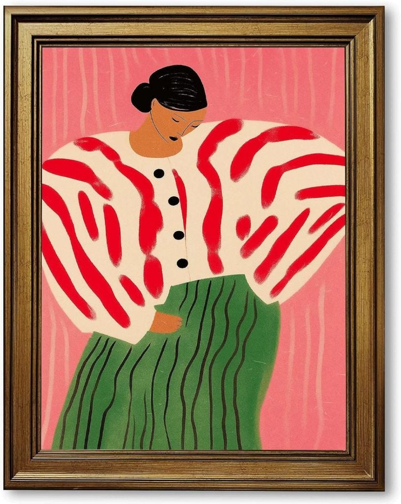 Framed painting of a person with dark hair in a bun, wearing a white and red patterned top with black buttons and a green skirt with vertical stripes, on a pink background.