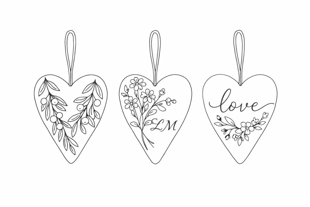 Three heart-shaped ornaments with hanging loops, each decorated with floral designs; the middle heart has "LM" and the right heart has the word "love" written on it.