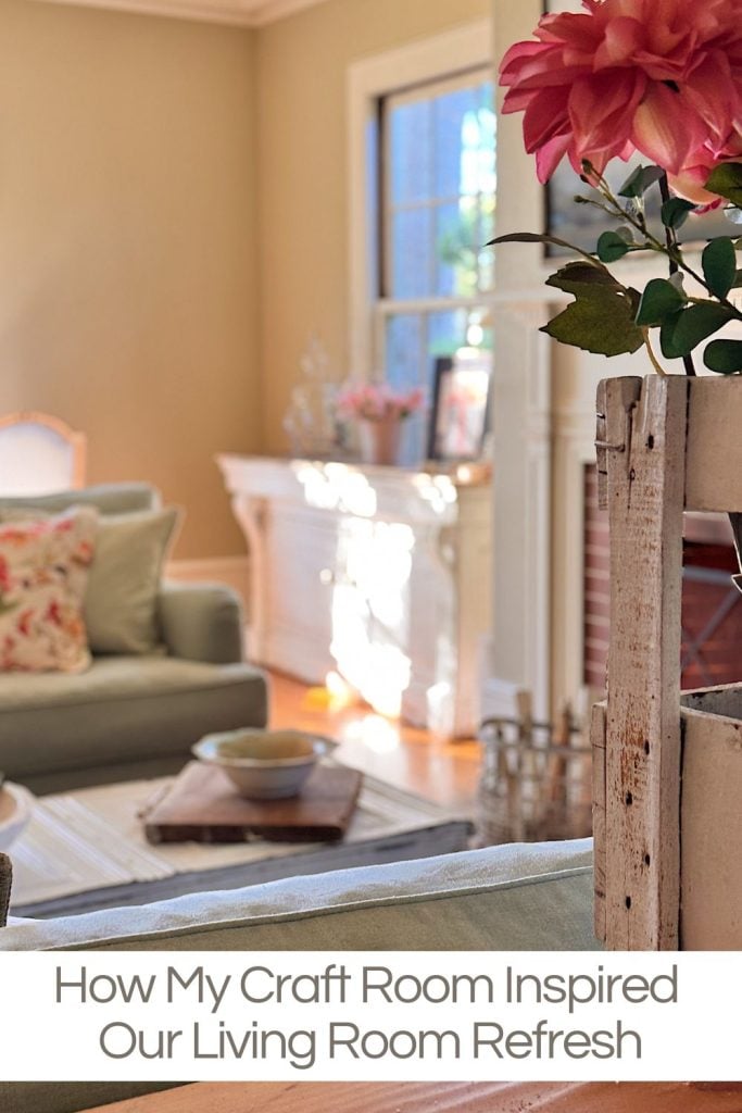 A bright living room with pastel furnishings, floral accents, and sunlight streaming through a window; text reads, "How My Craft Room Inspired Our Living Room Refresh.