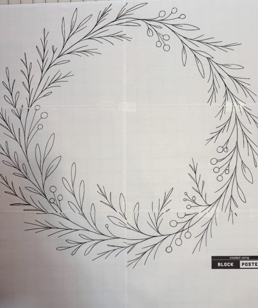 A black and white line drawing of a circular wreath made of leaves and small berries, printed on grid paper.