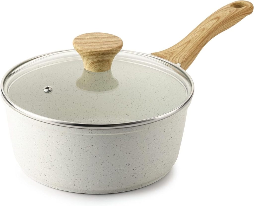 A white speckled saucepan with a glass lid and a light wood-patterned handle, shown on a plain white background.