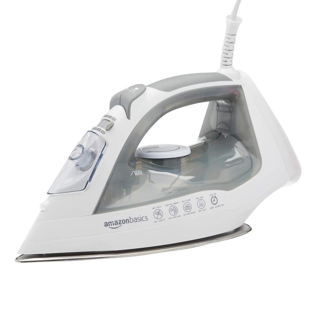 A white and gray electric steam iron with a transparent water reservoir, labeled "amazonbasics," placed on a white background.