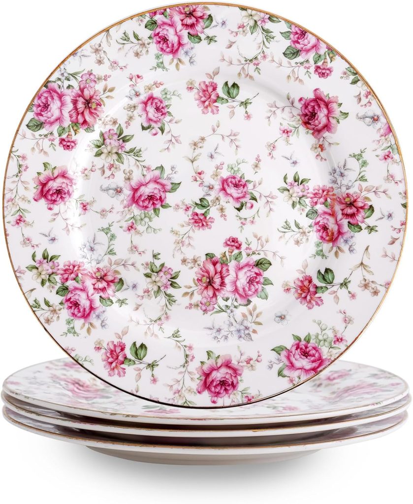 A stack of decorative porcelain plates with a pink and green floral pattern and gold-rimmed edges.