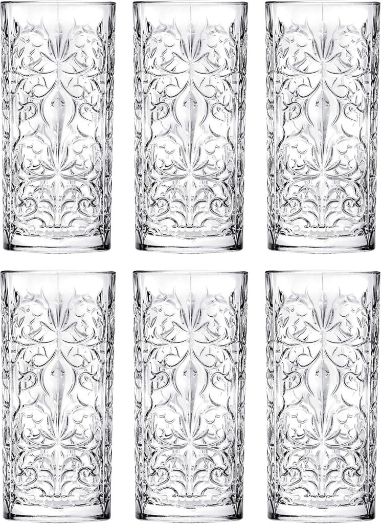 Six clear, tall drinking glasses with intricate, symmetrical etched patterns are arranged in two rows of three.