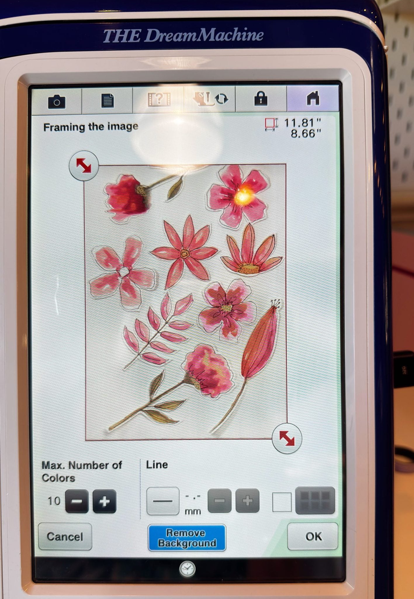 A sewing machine touchscreen displays a digital embroidery pattern of pink and red flowers with leaves, showing size and editing options.