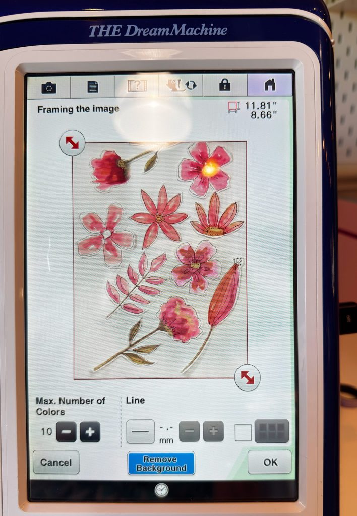 A sewing machine touchscreen displays a digital embroidery pattern of pink and red flowers with leaves, showing size and editing options.