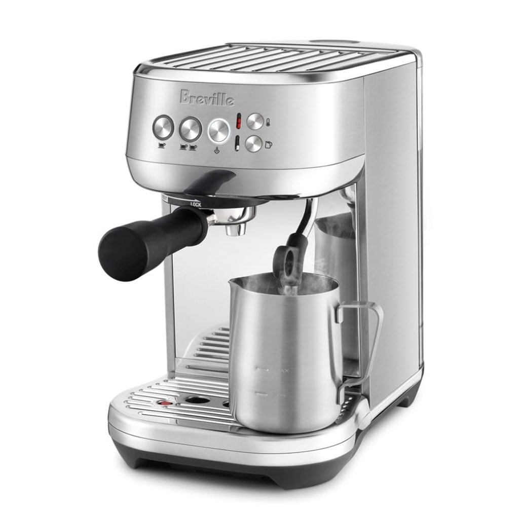 A stainless steel espresso machine with a steam wand frothing milk in a metal pitcher. Featuring several buttons and a portafilter attached, it&rsquo;s perfect for home baristas&mdash;discover deals during the Amazon Big Spring Sale.
