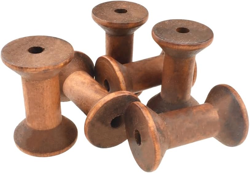 Five empty wooden spools arranged in a casual pile, each with a hole through the center.