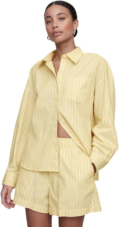 Person wearing a light yellow, pinstriped button-up shirt and matching shorts, standing with one hand in pocket against a plain white background&mdash;perfect for refreshing your wardrobe during the Amazon Big Spring Sale.