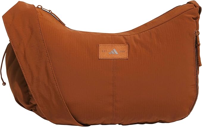 A brown crossbody bag with a zip closure and an Adidas logo patch on the front&mdash;perfect for grabbing at the Amazon Big Spring Sale.