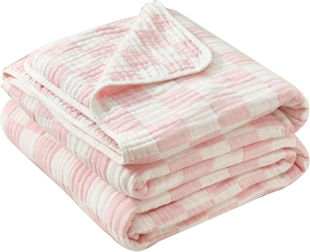 A folded pink and white checkered blanket with a quilted texture.