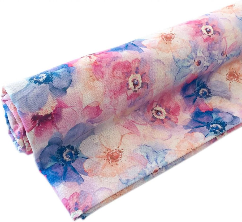 A rolled piece of fabric featuring a floral pattern in pink, purple, and blue tones on a light background.