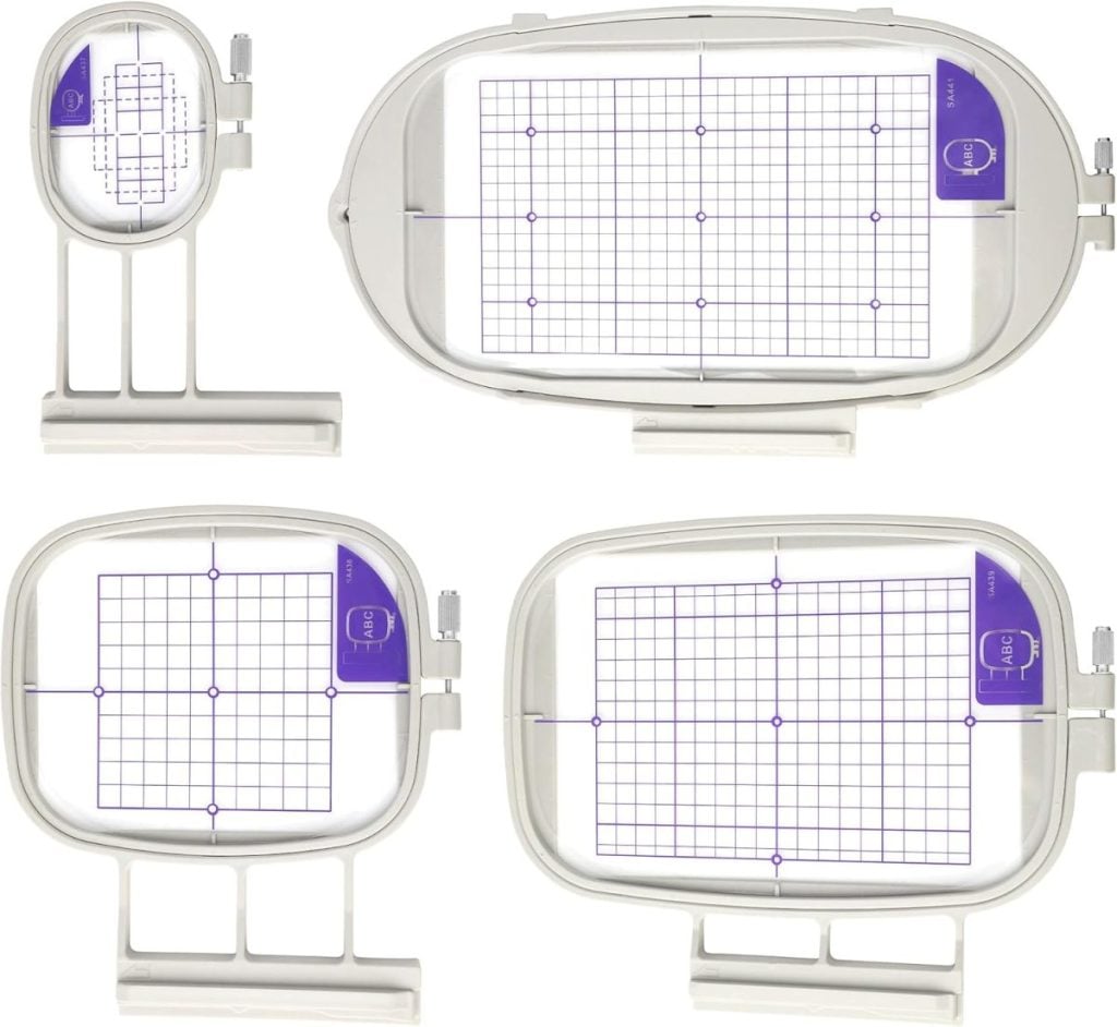 Four different sizes of white plastic embroidery hoops with purple grid inserts are shown on a white background.