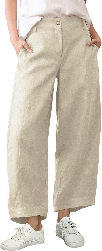 Person wearing wide-leg beige linen pants, white t-shirt, and white sneakers, with hands in pockets, standing against a plain background&mdash;perfect inspiration for your next look during the Amazon Big Spring Sale.