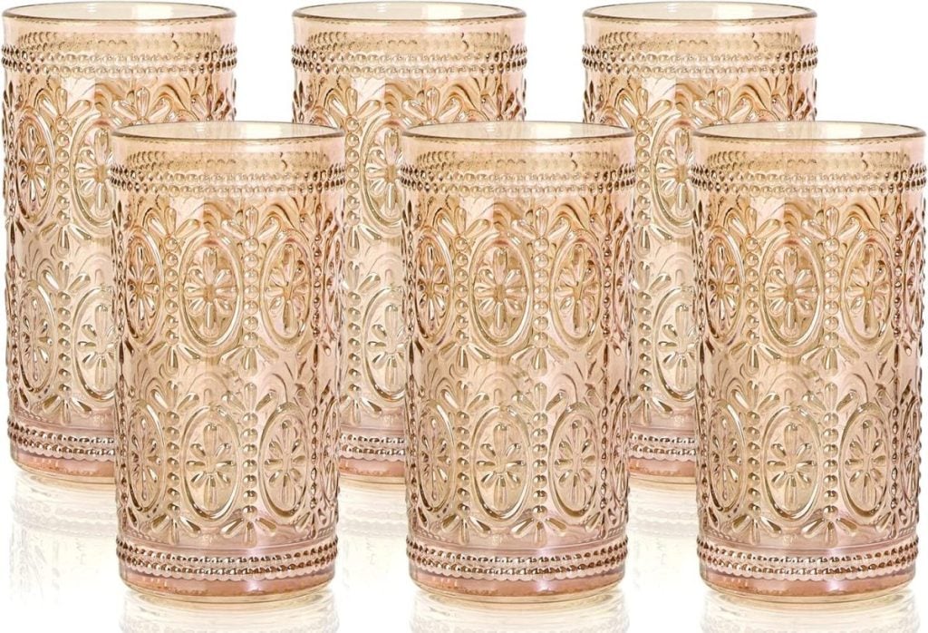 Six ornate, rose-colored glass tumblers with intricate embossed patterns, arranged in two rows of three on a white background—perfect for elevating any "day in my life" moment.