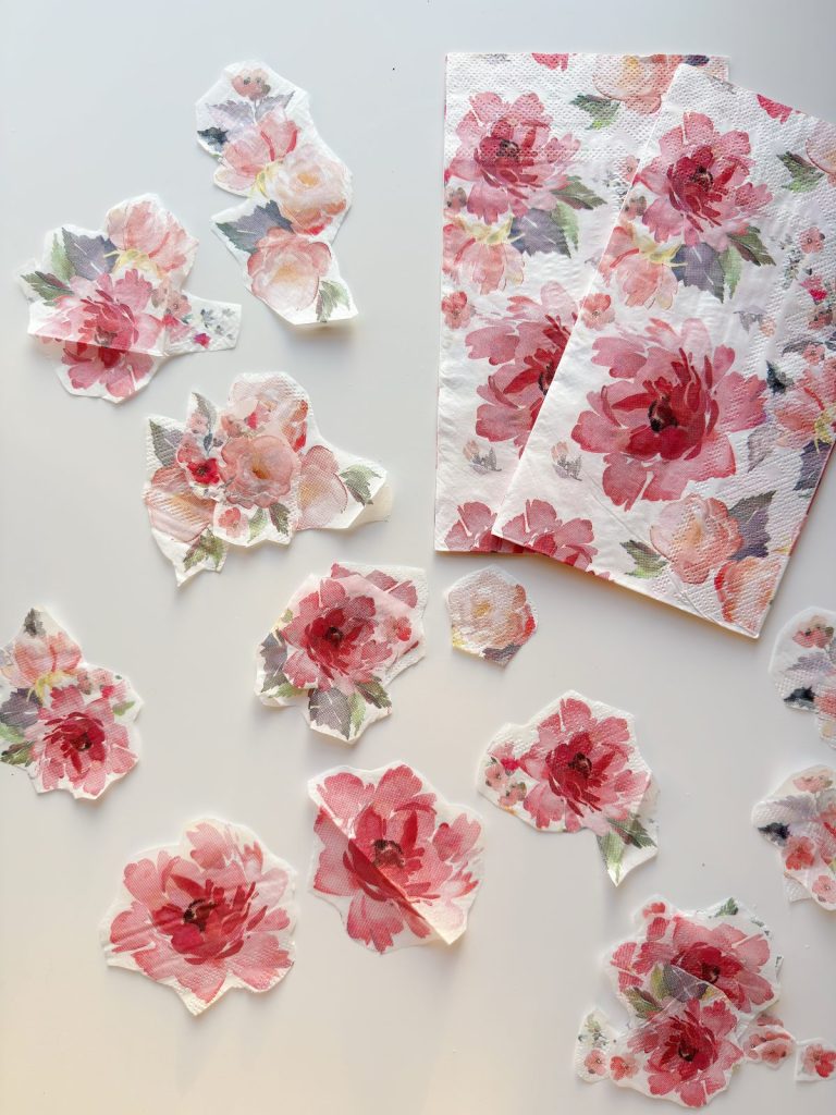 Floral paper napkins and several individual floral cutouts arranged on a white surface.