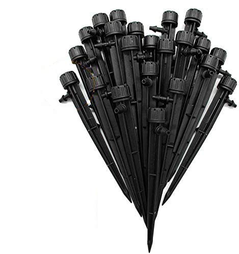 A bundle of black plastic adjustable drip irrigation emitters with pointed stakes arranged in a fan shape—perfect for efficient watering when learning how to grow tomatoes.