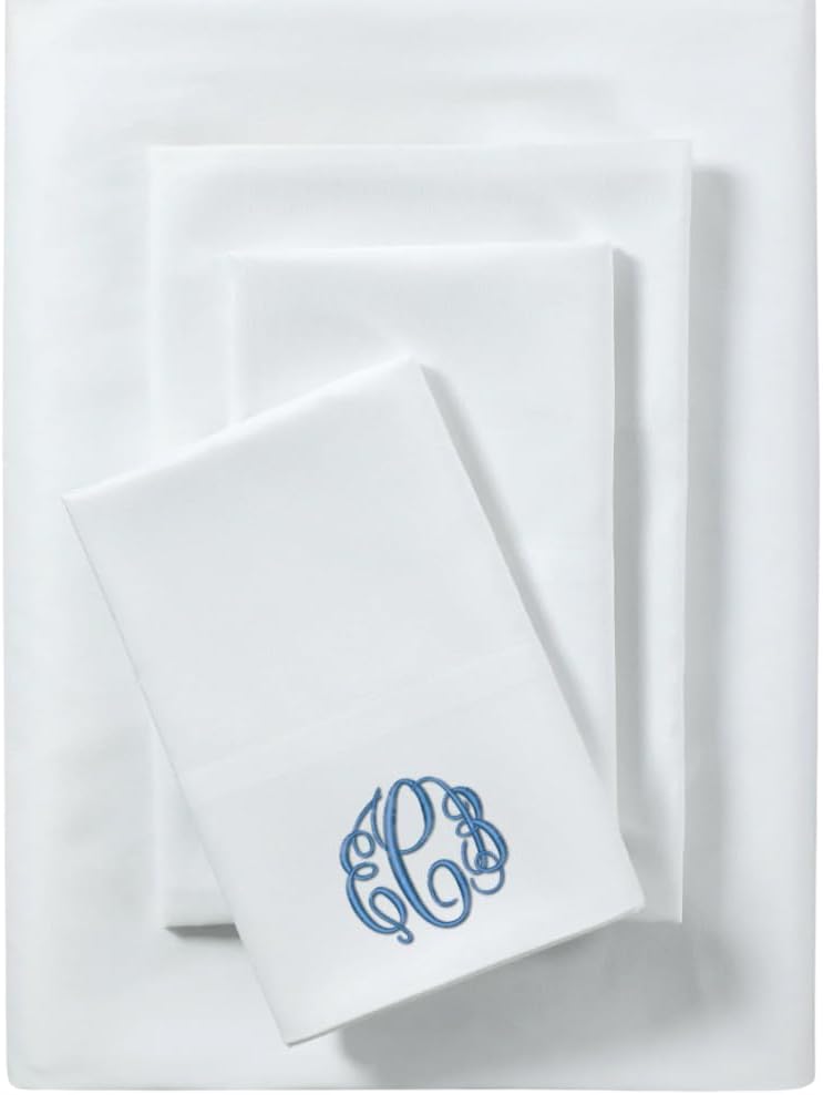 A set of neatly folded white bed sheets, with one sheet displaying an ornate blue monogram.