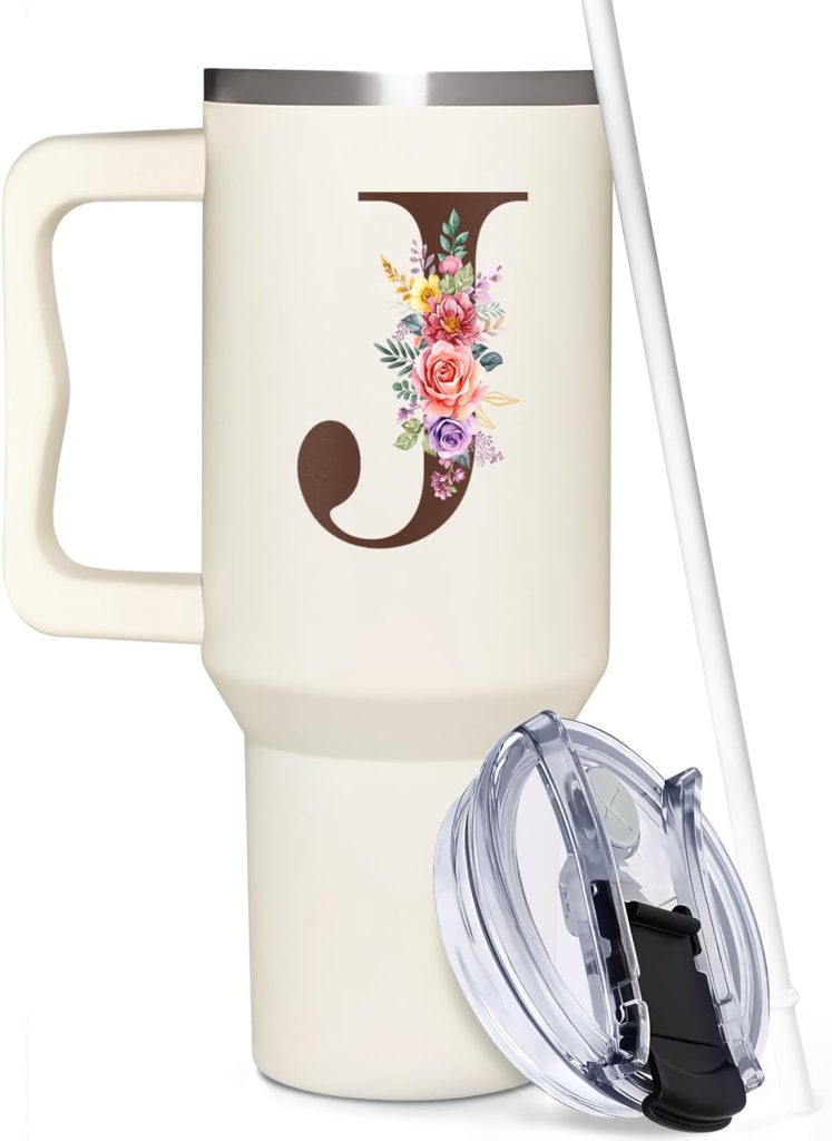 A cream-colored travel mug with a handle, floral letter "J" design, clear lid, and a white straw.