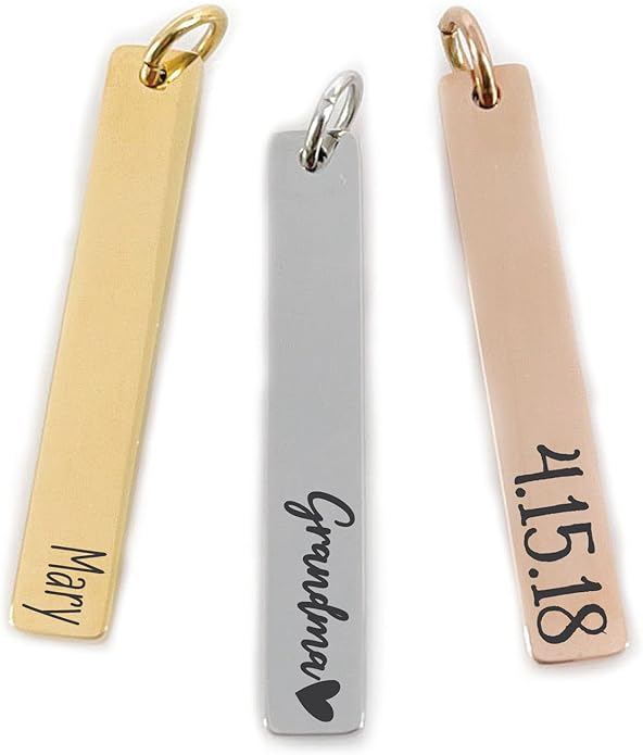 Three rectangular metal pendants in gold, silver, and rose gold colors with engraved text: "Mary," "Grandma &hearts;," and "4.15.18.