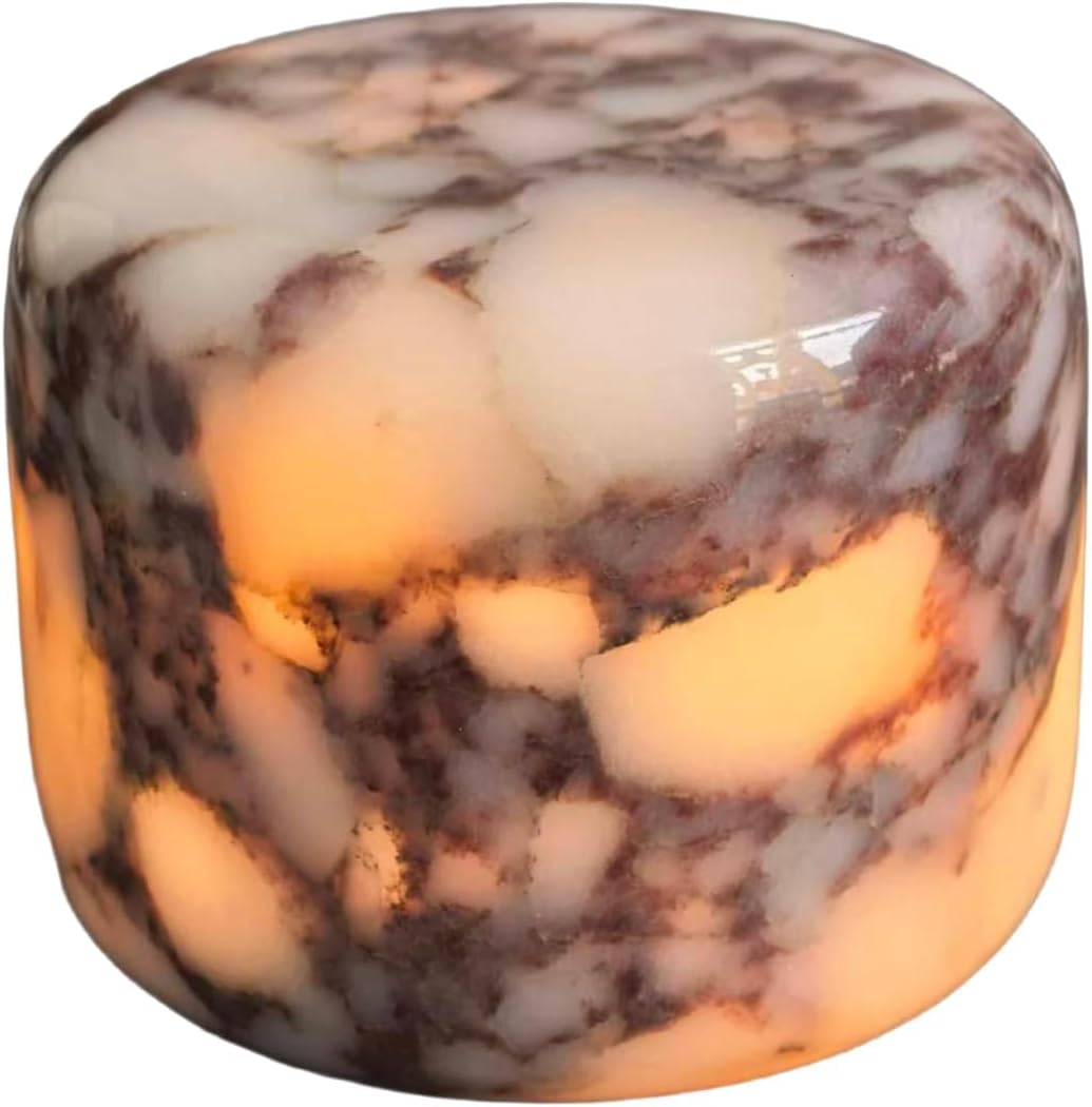 A cylindrical alabaster lamp emits a warm, soft glow through its marbled white and brown stone surface&mdash;an elegant choice among Mother's Day Gifts on Amazon.