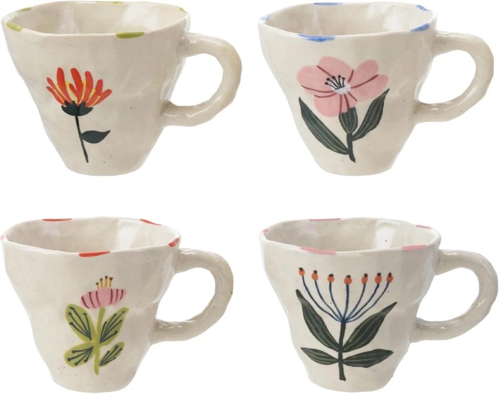 Four ceramic mugs with a rough finish, each featuring a unique hand-painted floral design in different colors&mdash;perfect as Mother's Day Gifts. Find these charming mugs on Amazon.