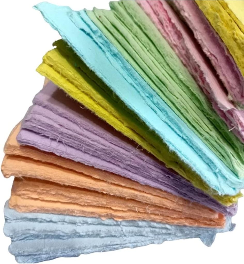 A stack of textured, handmade paper sheets in various pastel colors, including blue, orange, purple, yellow, green, and pink.