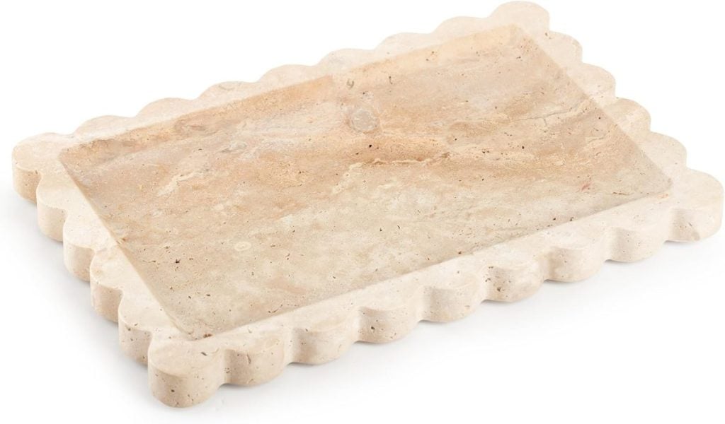 A rectangular beige stone tray with scalloped edges, viewed at an angle against a white background&mdash;perfect for chic Mother's Day gifts on Amazon.