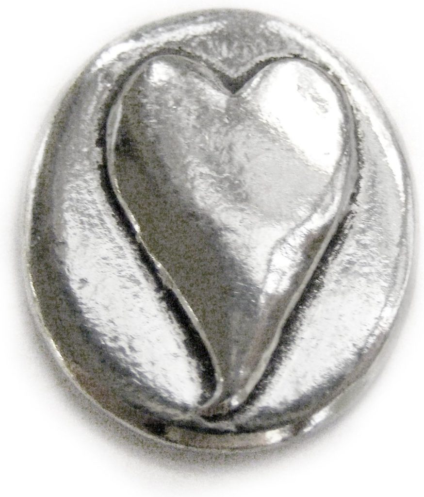 A silver oval-shaped metal token with a raised heart design in the center.