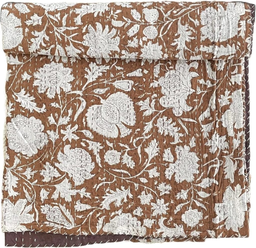 A folded brown fabric with a white floral and leaf pattern, featuring quilted stitching along the edges&mdash;an elegant choice for Mother's Day Gifts Amazon shoppers will love.