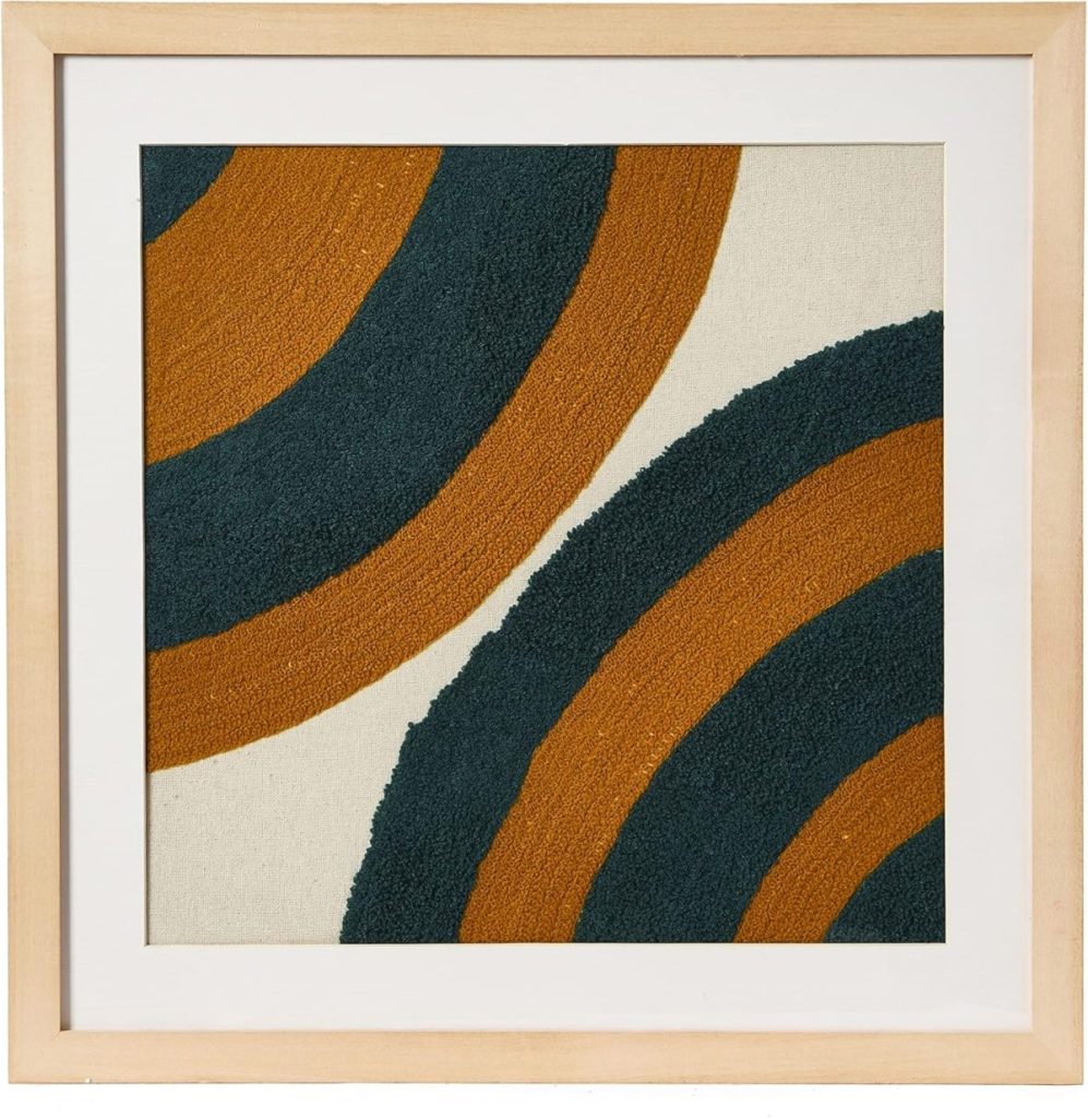 Framed artwork featuring two intersecting semicircles with alternating dark green and burnt orange stripes on a beige background.
