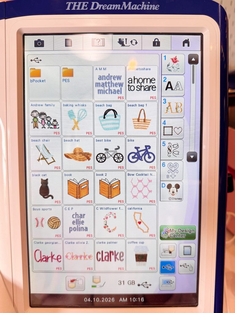 A touchscreen display shows embroidery design options, including text, icons, and images such as a bike, basket, book, and names like "Clarke" and "andrew matthew michael.