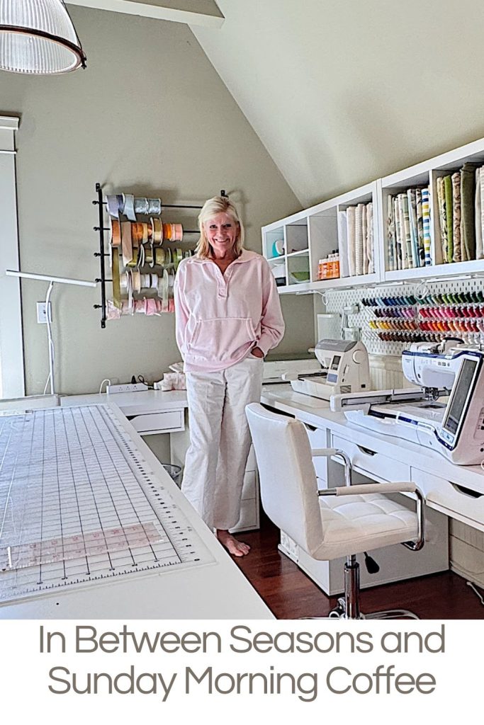 A woman stands in a bright sewing room with organized fabric, thread, and ribbon, next to sewing machines and a large cutting table. Text reads "In Between Seasons and Sunday Morning Coffee.