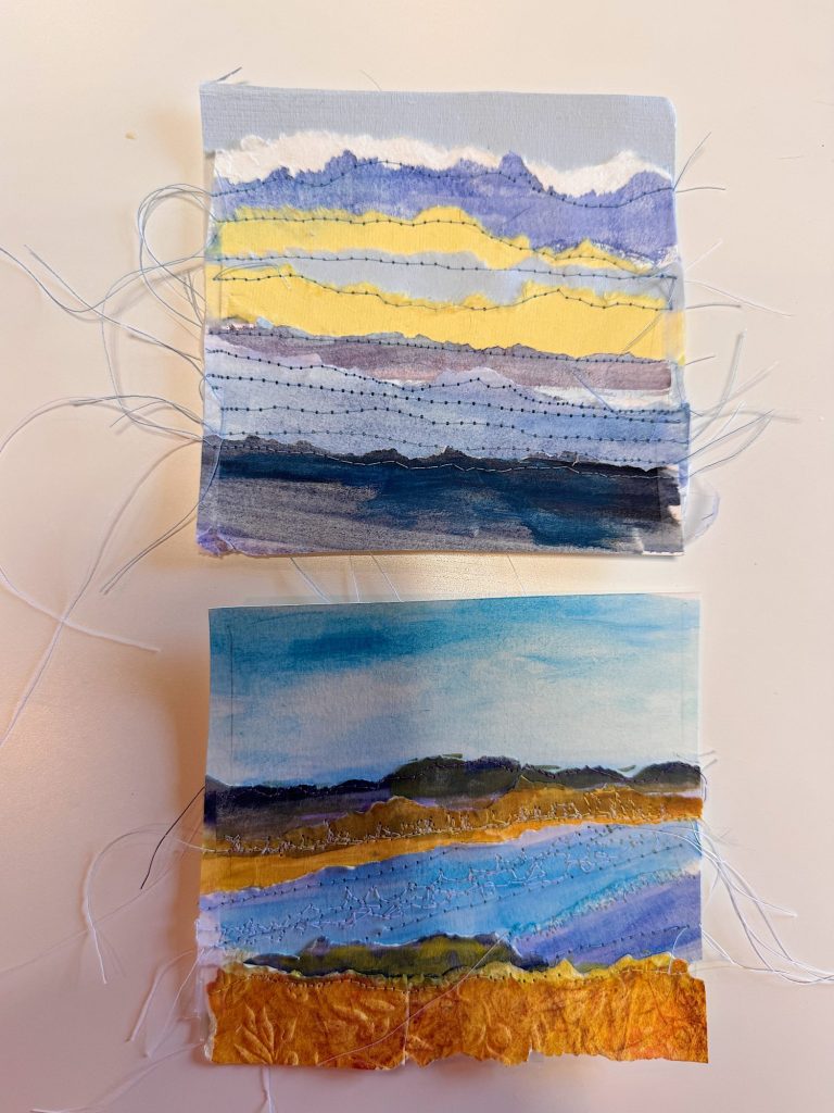 Two small square textile artworks with loose threads, depicting abstract landscape scenes in layered blue, yellow, and orange colors.