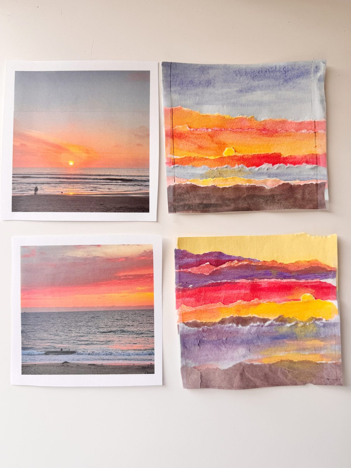 Two printed photos of ocean sunsets are displayed alongside two watercolor paintings that recreate the sunset scenes, all arranged on a white surface.