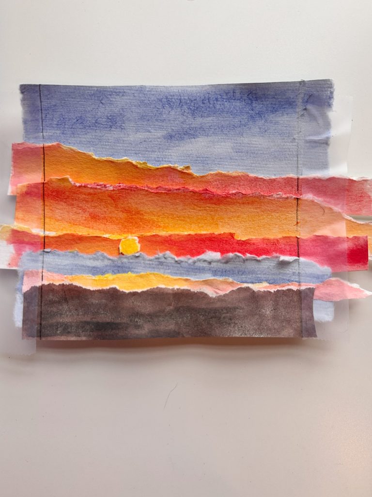 A collage of torn paper painted with watercolor depicting a sunset with blue, orange, red, and dark brown tones on a white background.