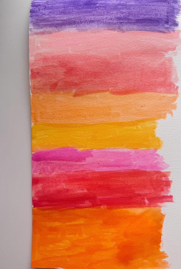 A sheet of paper with horizontal watercolor stripes in purple, pink, orange, yellow, and red on a white background.