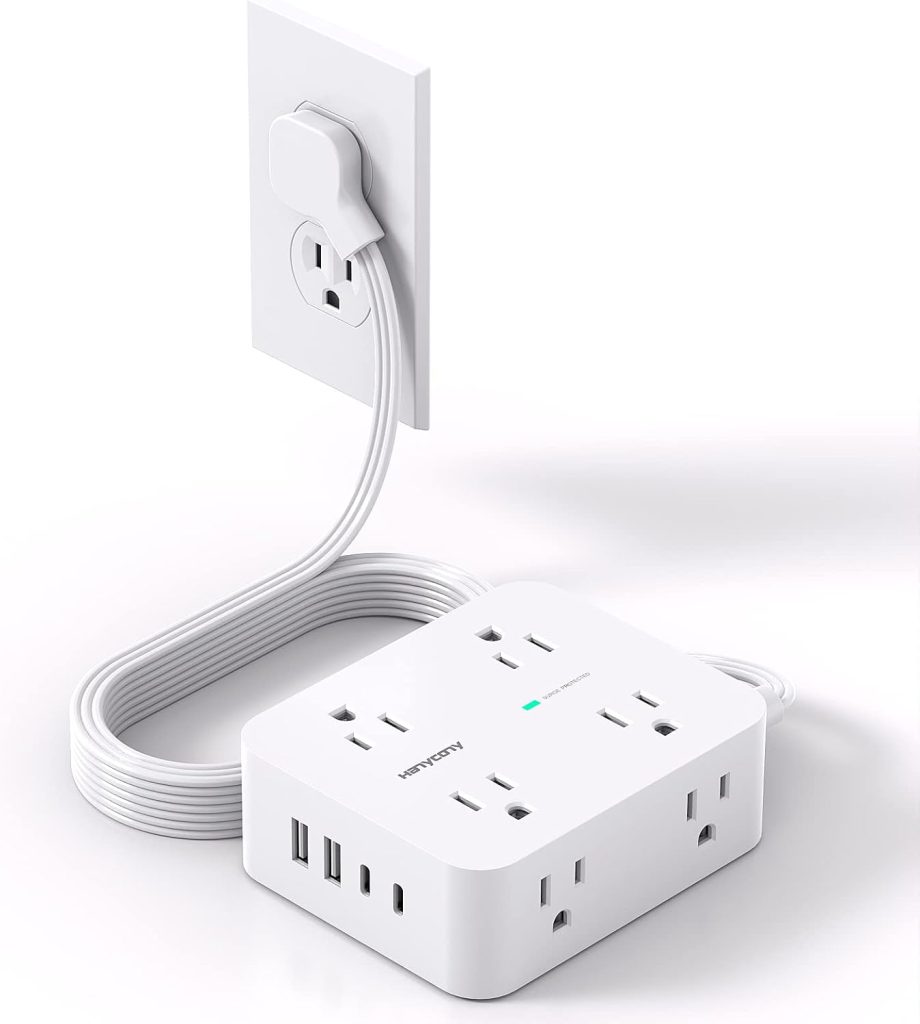 A white power strip with six AC outlets and three USB ports is plugged into a wall socket with a long extension cord.