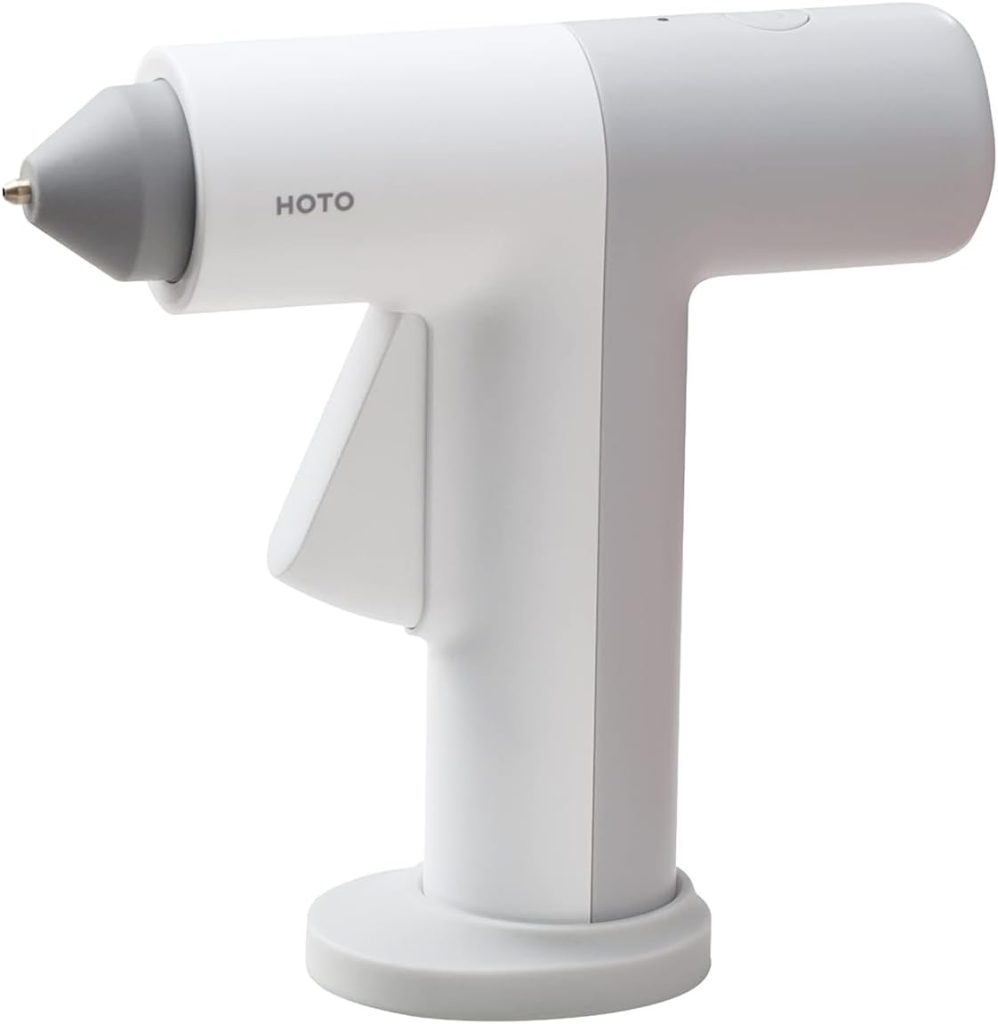 A white, cordless hot glue gun with a gray tip and the brand name "HOTO" printed on the side, standing upright on its base&mdash;perfect for your next coastal mirror DIY project.