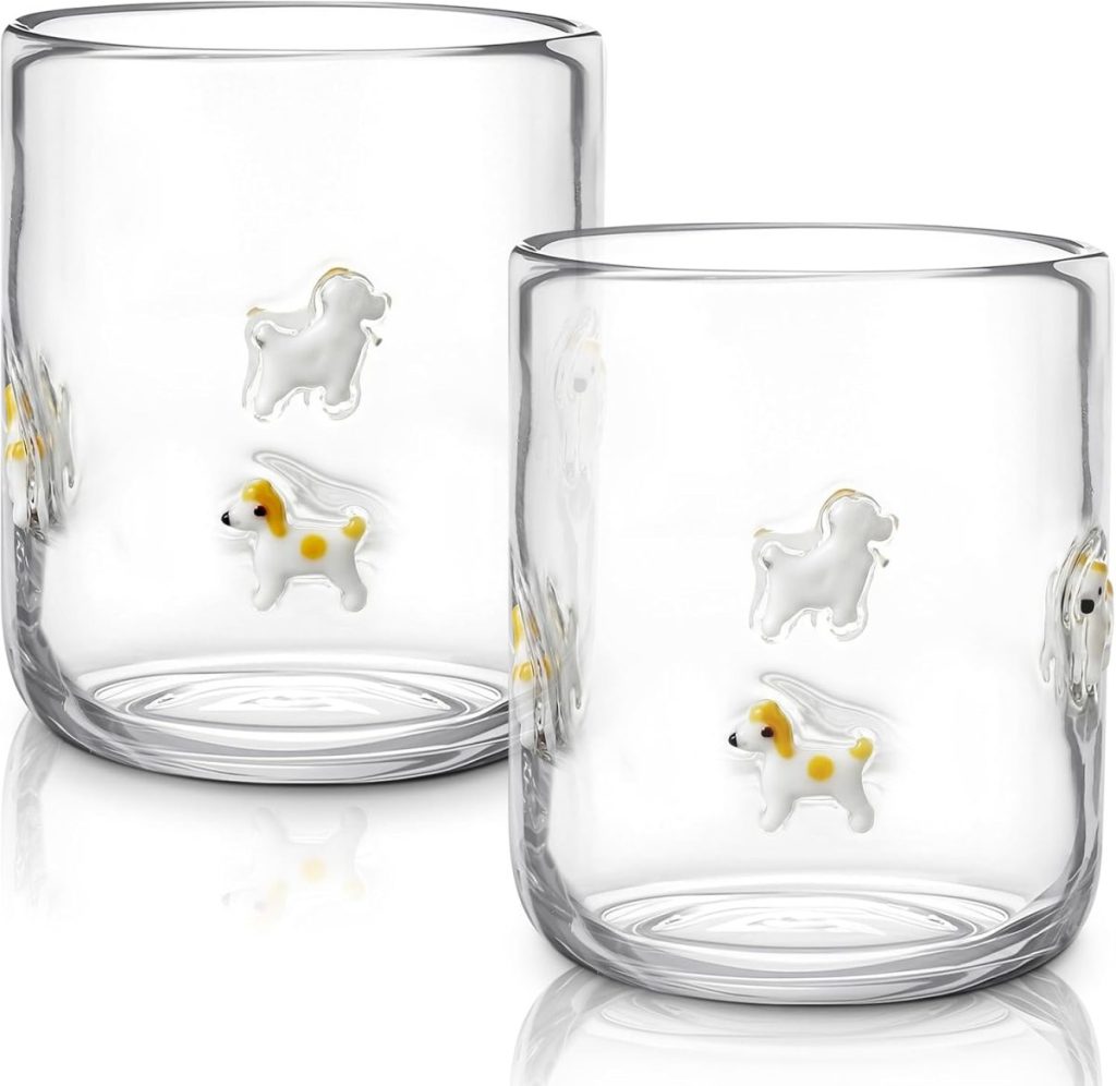 Two clear glass tumblers featuring small, raised dog designs with yellow spots on their sides—perfect for pairing with embroidered cocktail napkins at your next gathering.