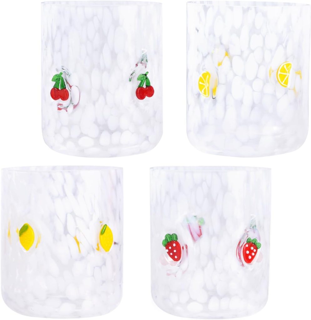 Four white speckled glass tumblers, each decorated with colorful fruit designs including cherries, lemons, strawberries, and limes—perfect for pairing with your favorite embroidered cocktail napkins.
