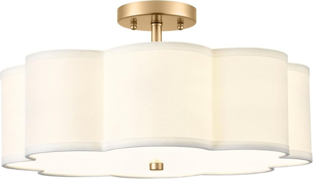 A semi-flush mount ceiling light with a scalloped white fabric shade and a brass base.