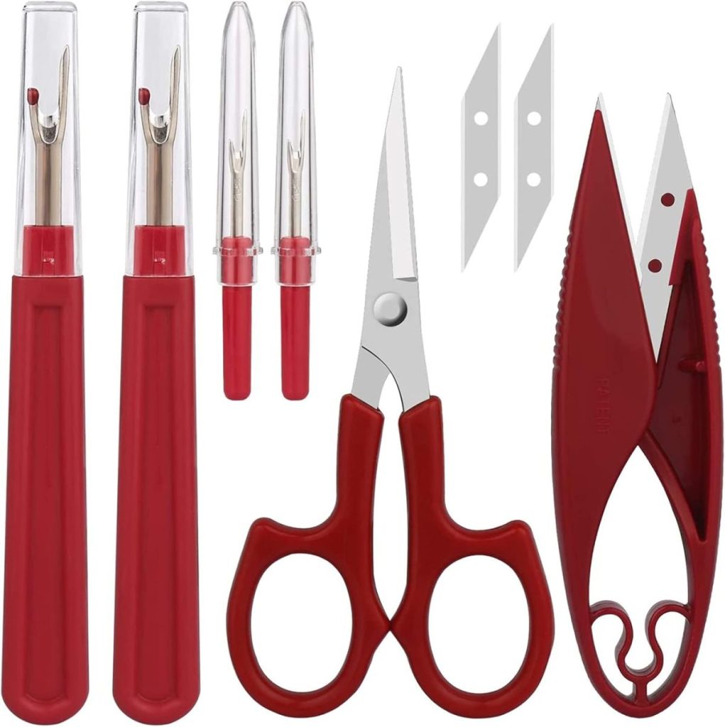 A sewing tool set with three seam rippers, two replacement blades, a pair of red-handled scissors, and a red thread snip, all arranged on a white background.